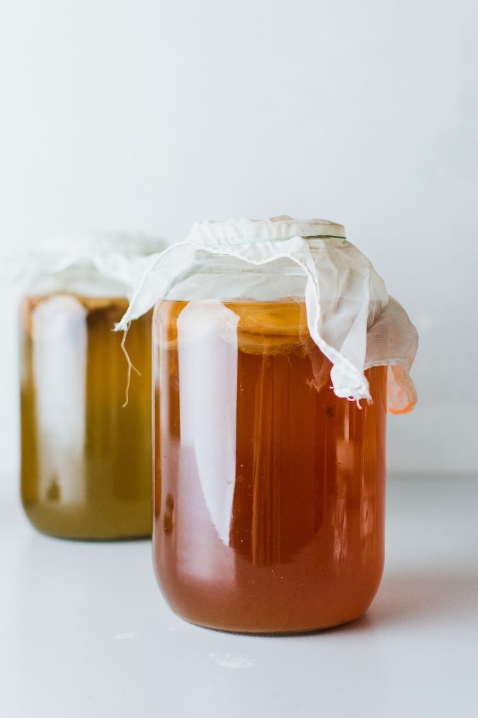 two mason jars filled with liquid on white surface